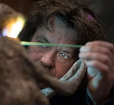 Boud Ceysens aan het werk met een vlam in zijn atelier.