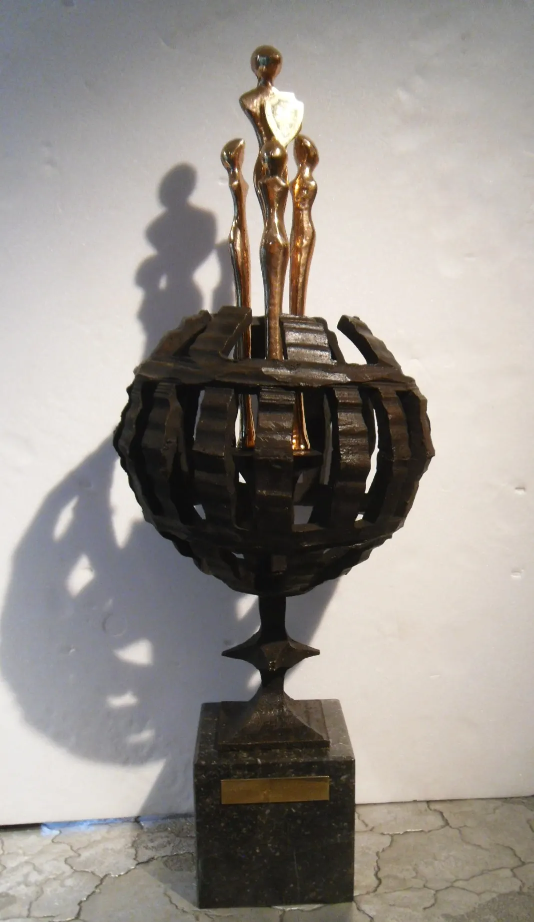 JCI Award: drie figuren op een bronzen wereldbol.