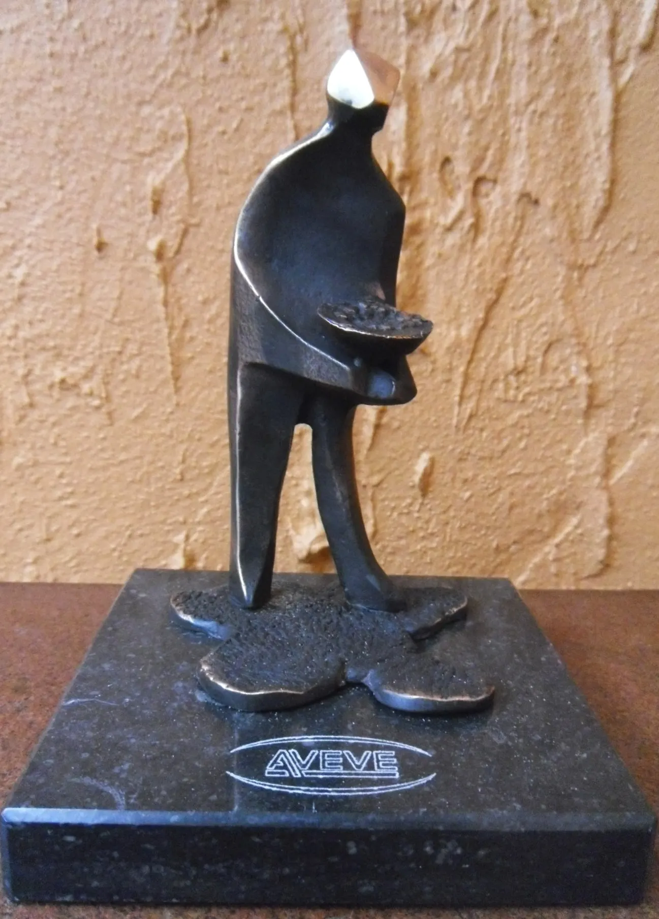 De Zaaier: bronzen figuur die zaait, op een granieten sokkel met het logo van Aveve.